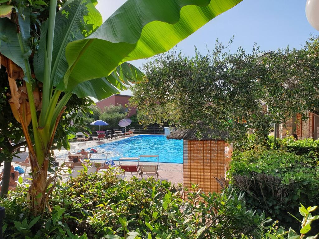 a swimming pool with tables and chairs and trees at Campeggio Gianna Golfo dei Poeti in Lerici
