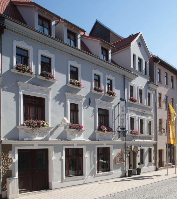 a large white building with flowers in the windows at Ringhotel Schlossberg in Neustadt