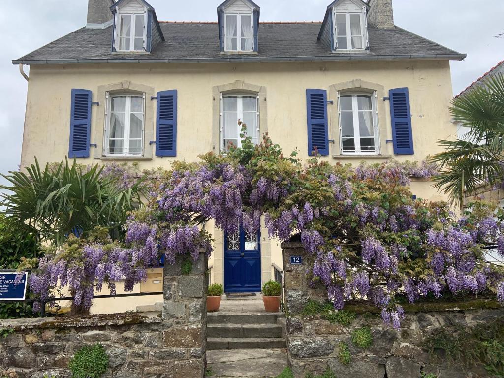 a house with purple flowers on the front of it at St Guenole&#39; Studio Apartment in Landévennec