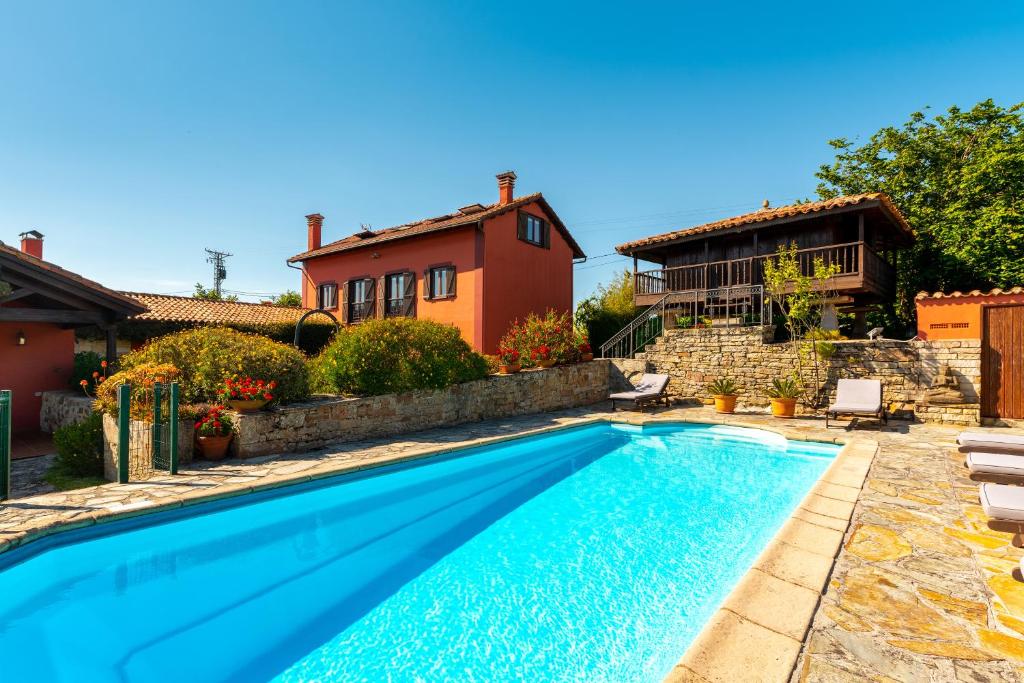 a swimming pool in front of a house at Casa de Aldea con Piscina Calefactada in Villaviciosa