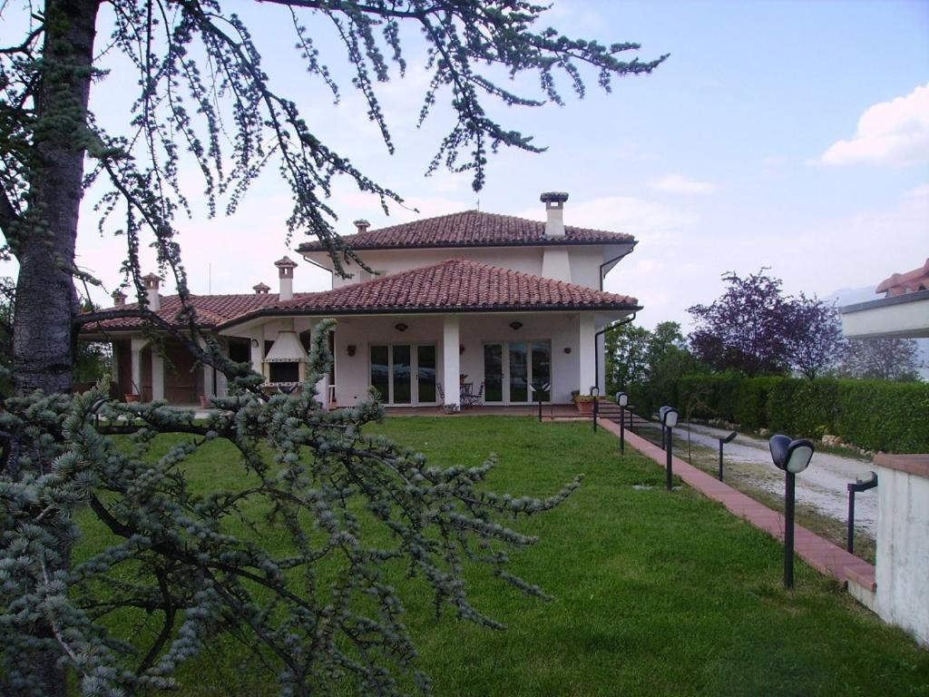 una casa con un cortile verde davanti di Villa Linda Bed And Breakfast a Sulmona