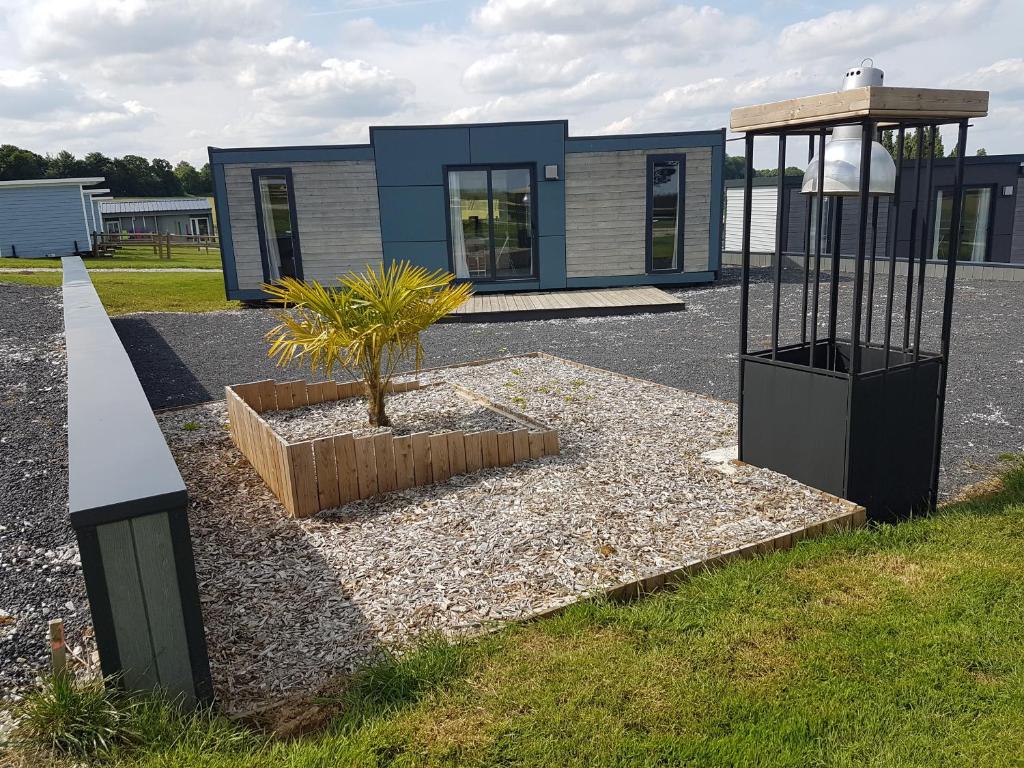 une petite maison avec un palmier en face dans l'établissement Village Guerzaille, à Saint-Caradec