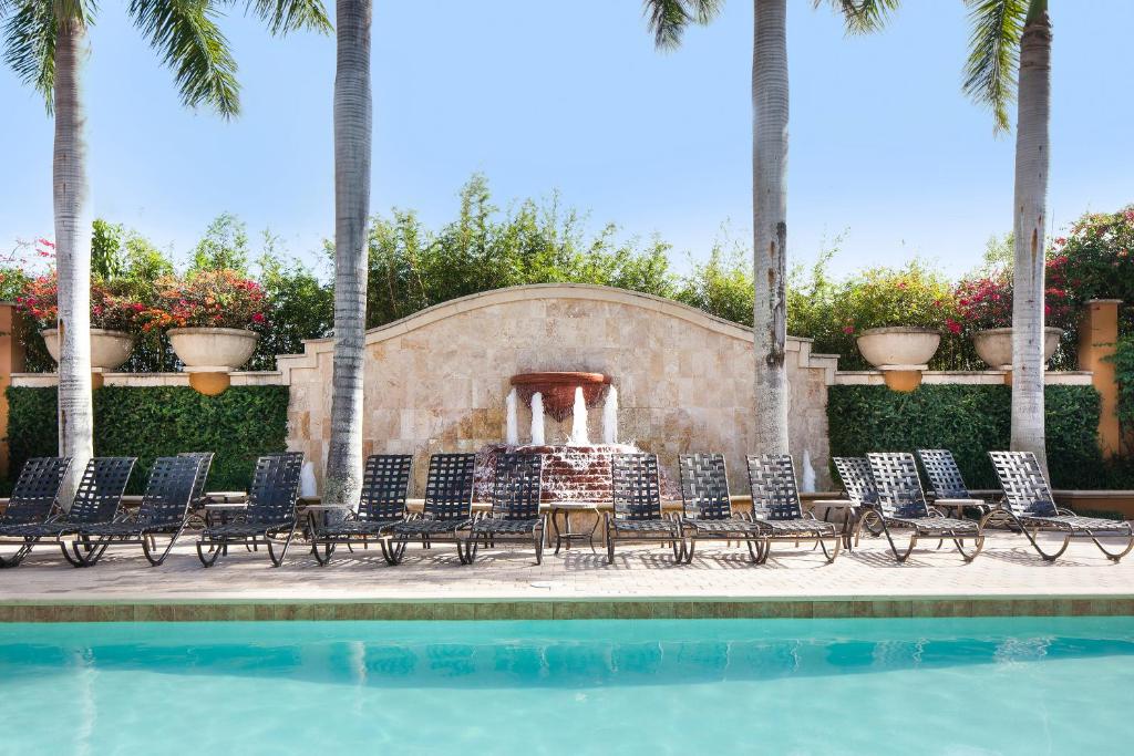 a swimming pool with chairs and a fountain at Bellasera Resort in Naples
