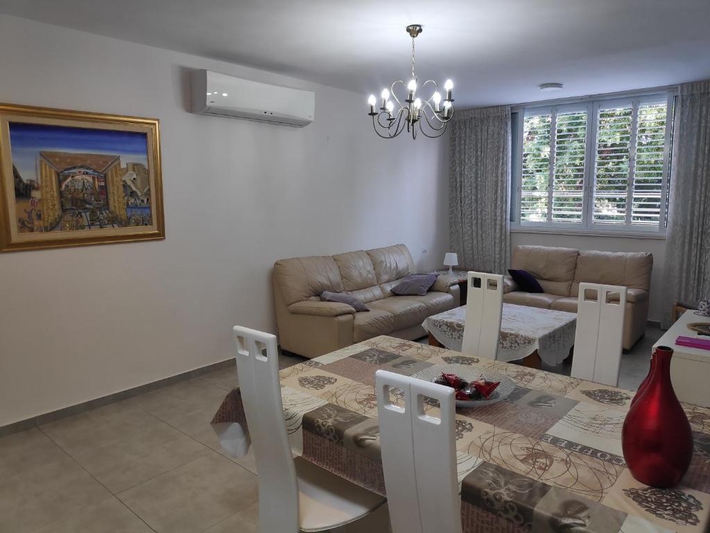 een woonkamer met een tafel en een bank bij Herzliya Center Apartments in Herzelia 