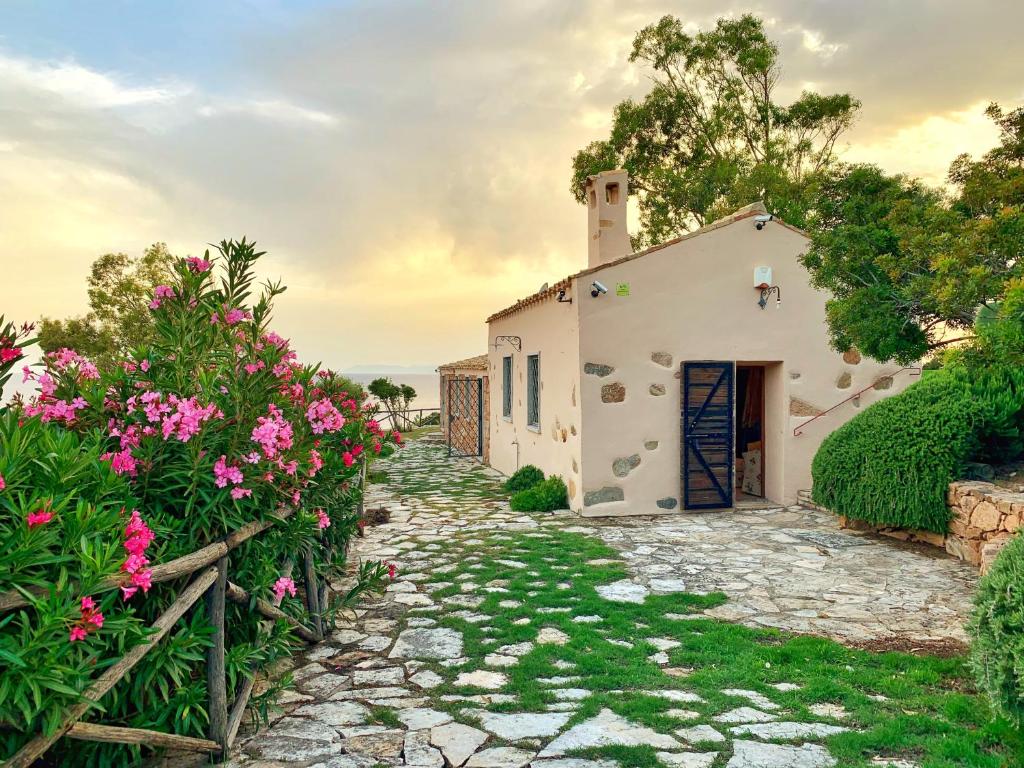 een wit huis met een poort en bloemen bij Angolo di paradiso sul mare in Geremèas