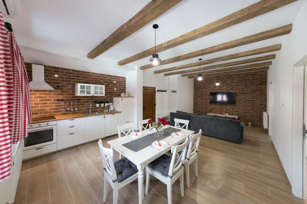 a kitchen and dining room with a white table and chairs at House Smolčić in Otočac