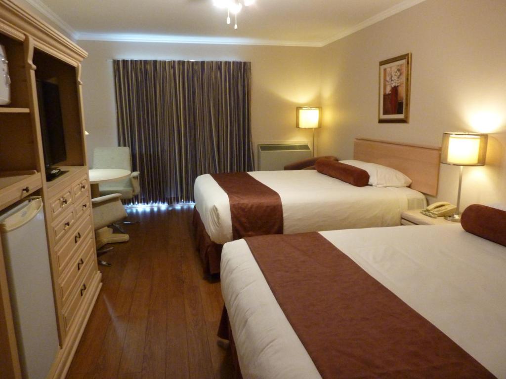 um quarto de hotel com duas camas e uma janela em Motel Becancour em Bécancour