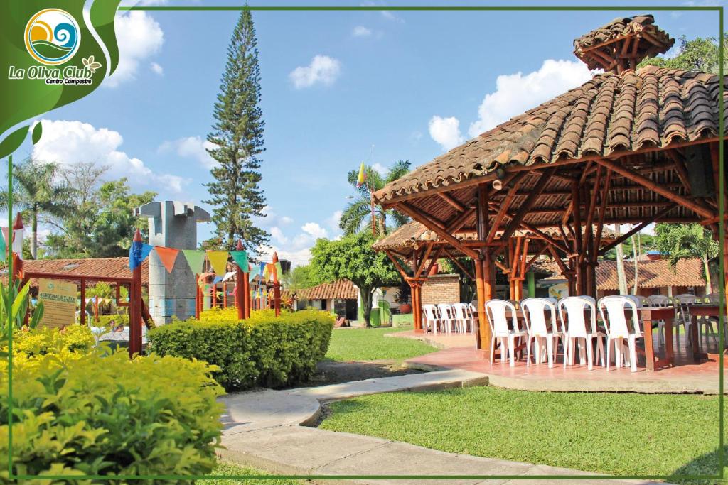 un cenador con sillas blancas y un parque infantil en La Oliva Club Centro Campestre, en La Gorgona