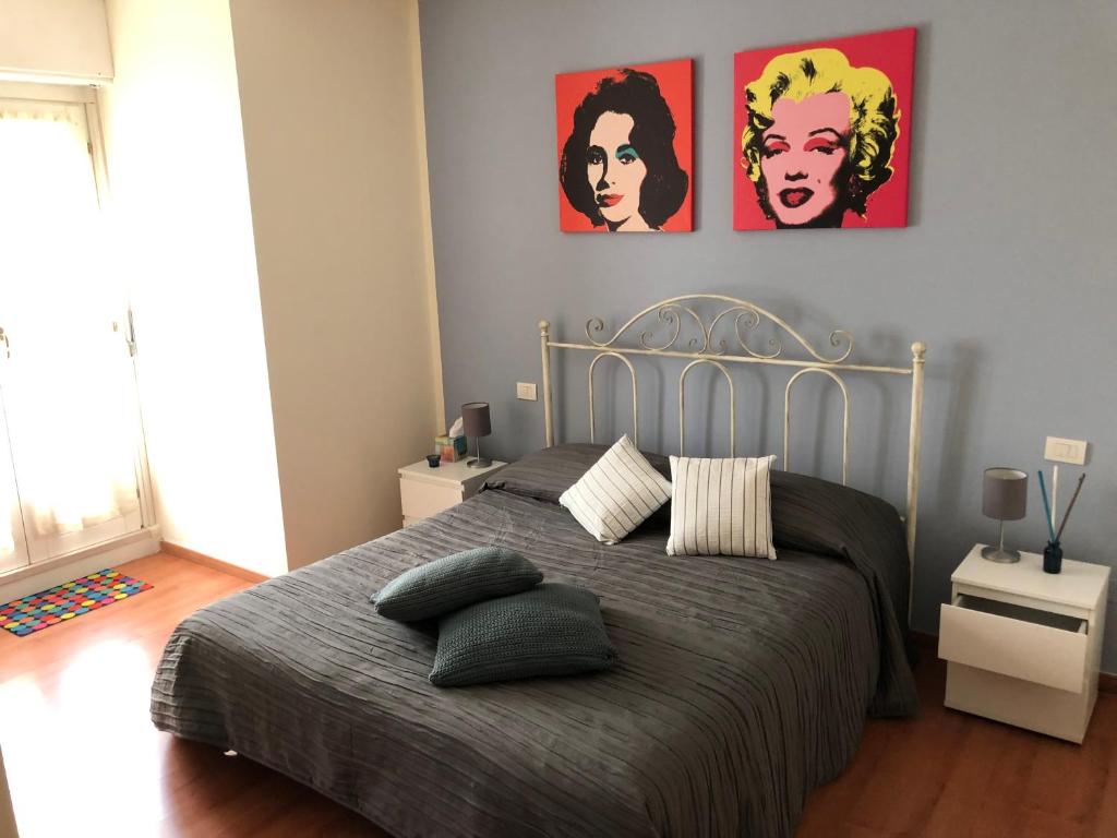 una camera da letto con un letto con due poster appesi al muro di Irides rooms a Lazise