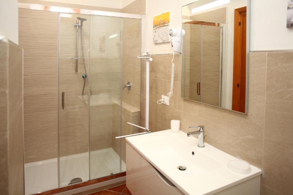a bathroom with a sink and a shower with a glass door at Country Villa San Vito Bay in San Vito lo Capo