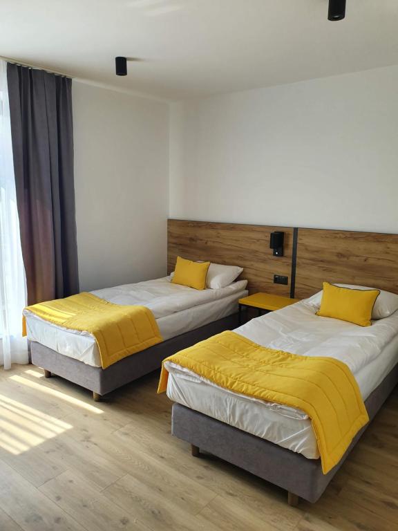VILLA 17 Noclegi في بلوك: سريرين في غرفة الفندق مع شراشف صفراء
