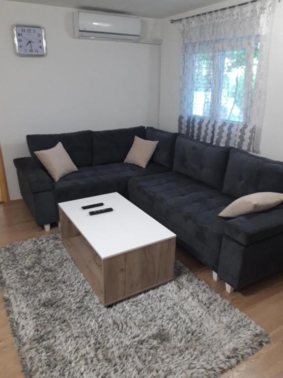 a living room with a blue couch with a coffee table at Apartman Miloš in Trebinje