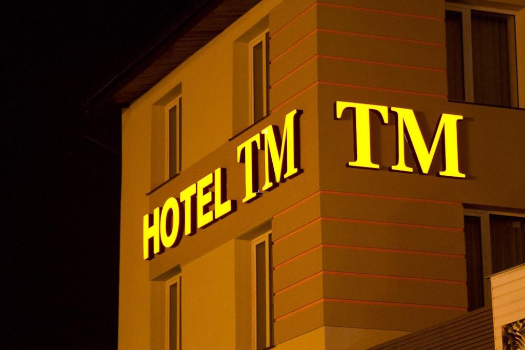 una señal de neón en el lateral de un edificio en Hotel TM en Radom