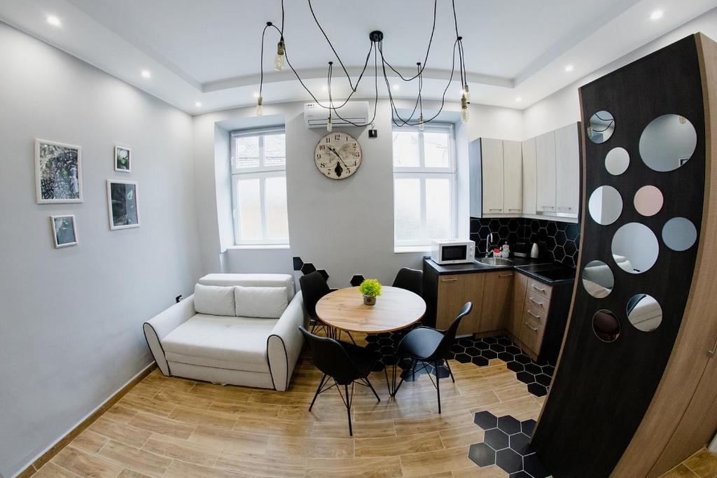 un soggiorno con tavolo e sedia e una cucina di Apartmani Galea a Sombor