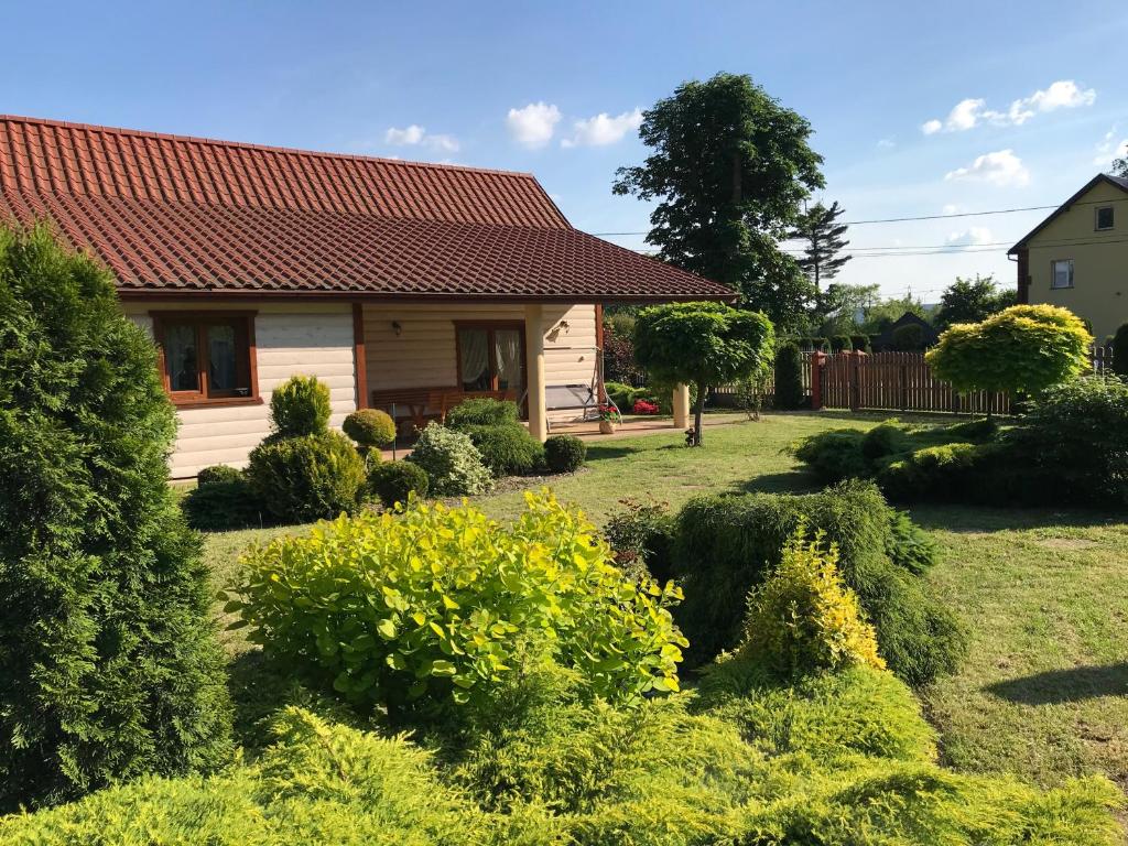 a small house with a yard with bushes at Chatka pod Dębami dla pracowników firm in Brzeźnica