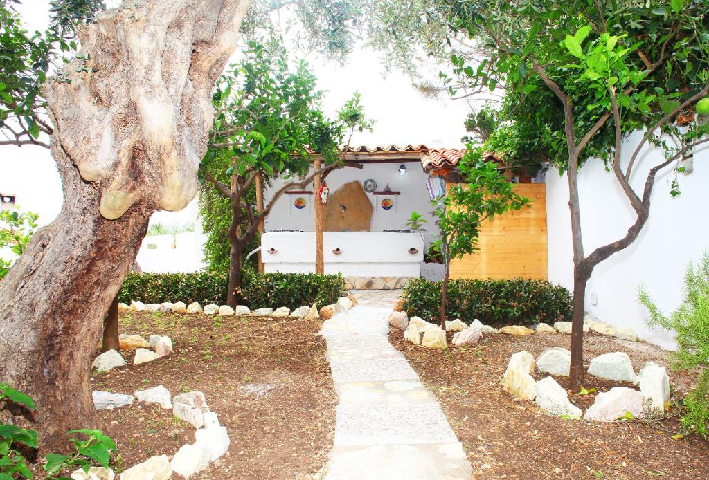a garden with a tree and a house at Country Villa San Vito Bay in San Vito lo Capo