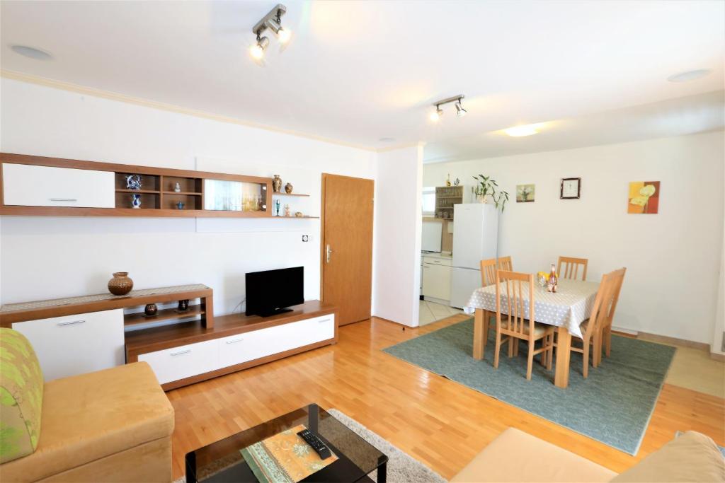 Una sala de estar con una mesa y una cocina. en Apartmani Vinko, en Baška Voda