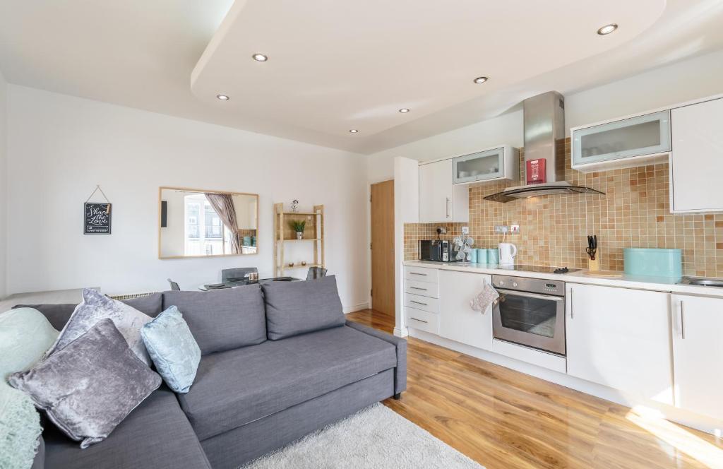 a living room with a couch and a kitchen at Luxury Central Newcastle Apartment 23 in Newcastle upon Tyne