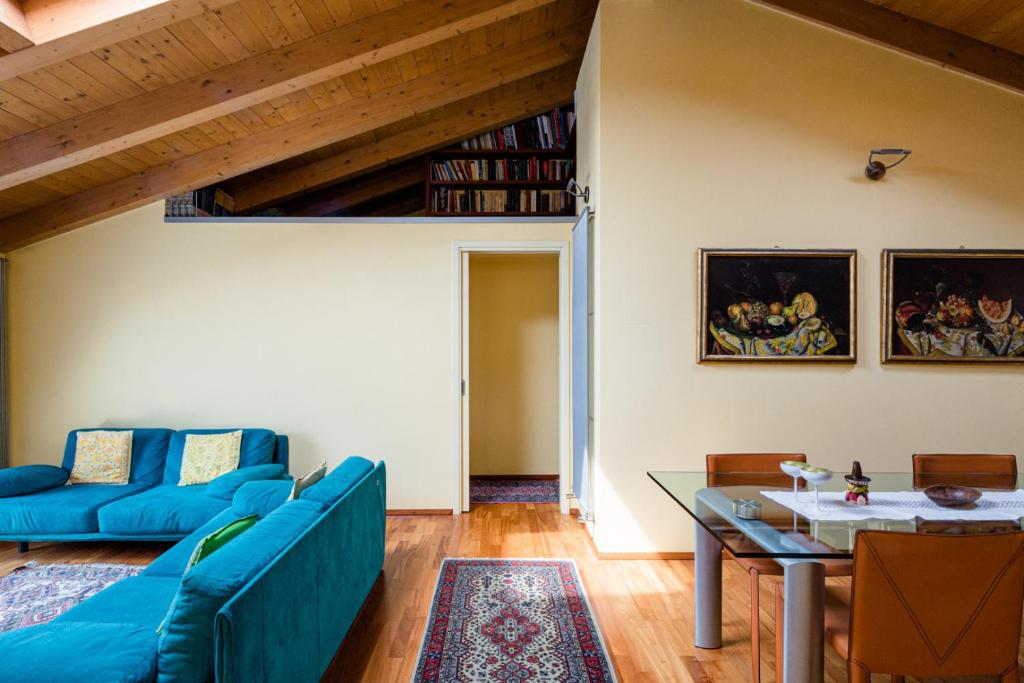 uma sala de estar com um sofá azul e uma mesa em Sentirsi a Casa em Boario Terme