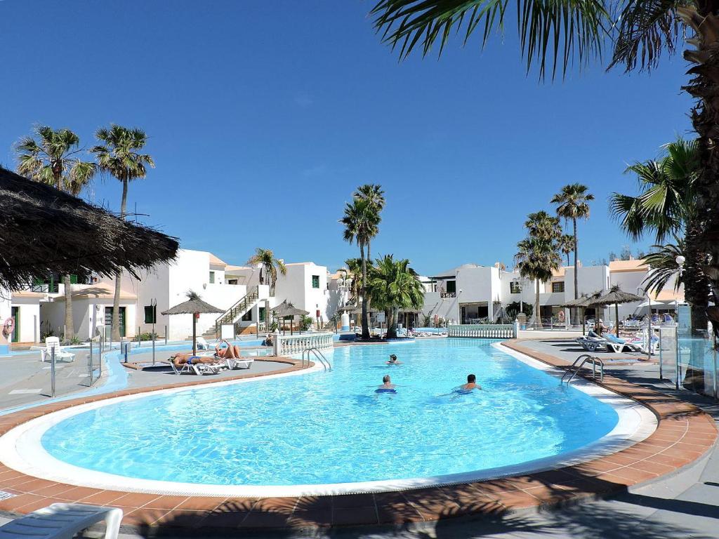 a large swimming pool with people in the water at Canary Islands getaway in Caleta De Fuste