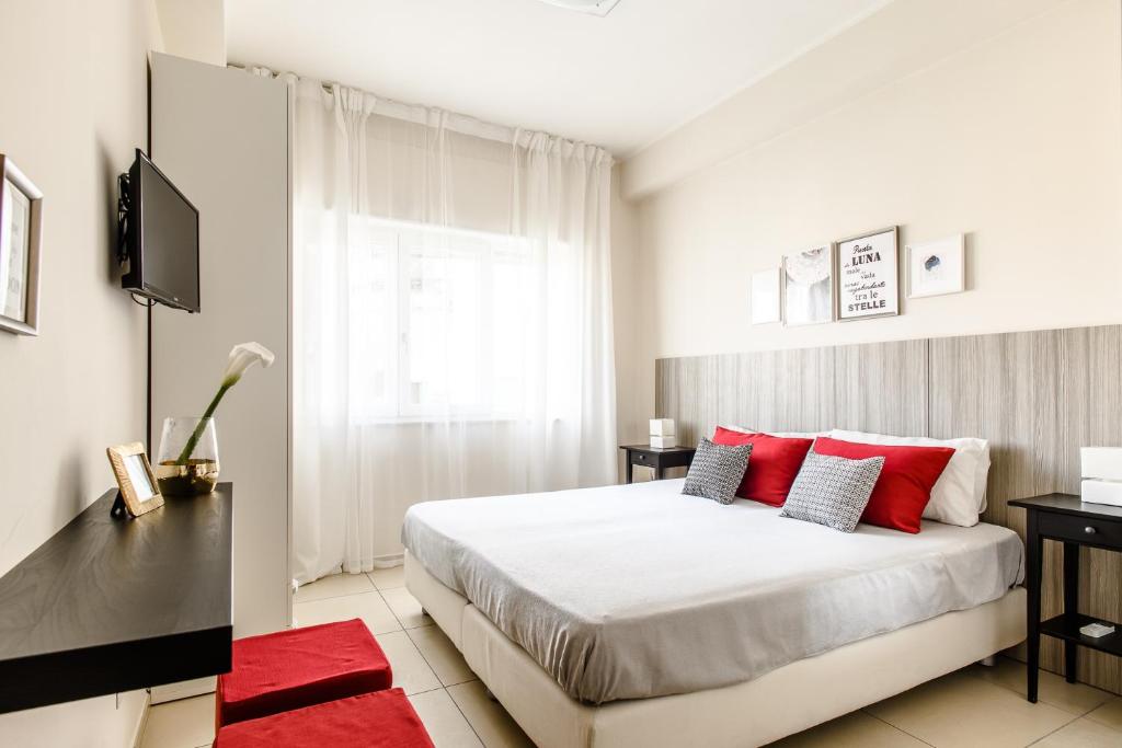 ナポリにあるToma la Lunaのベッドルーム1室(大型ベッド1台、赤い枕付)