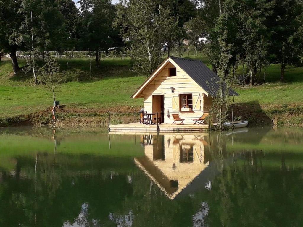 a small house sitting on top of a body of water at La cabane du pêcheur in Montcuq