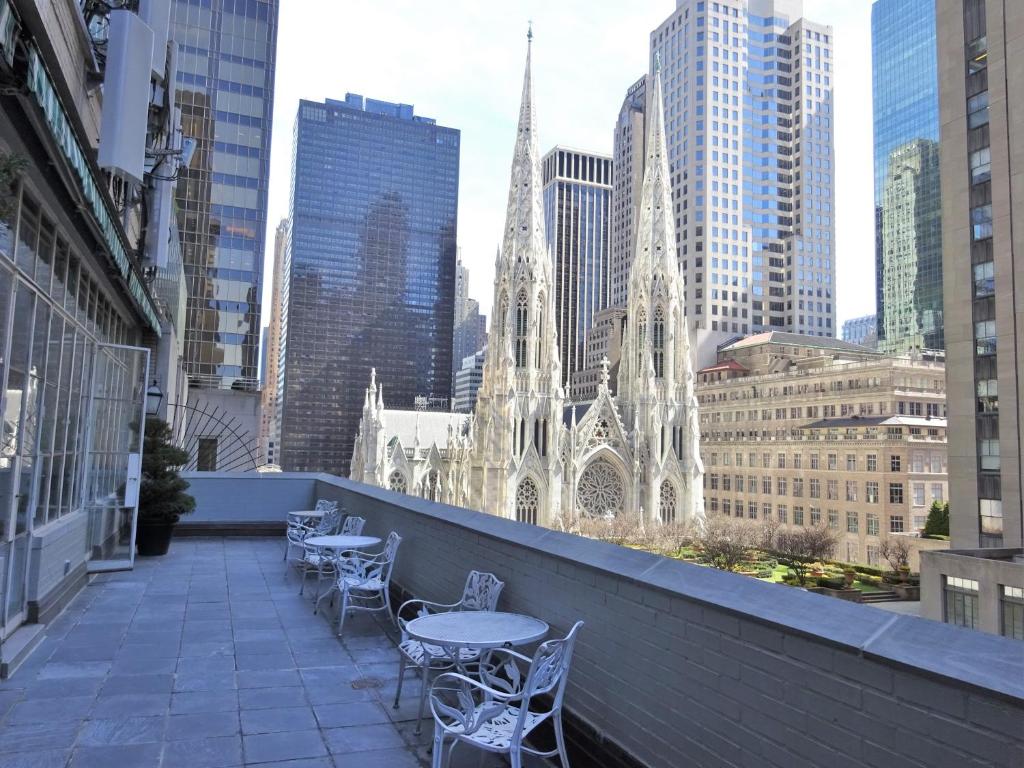 a balcony with tables and chairs and a cathedral at 3 West Club in New York