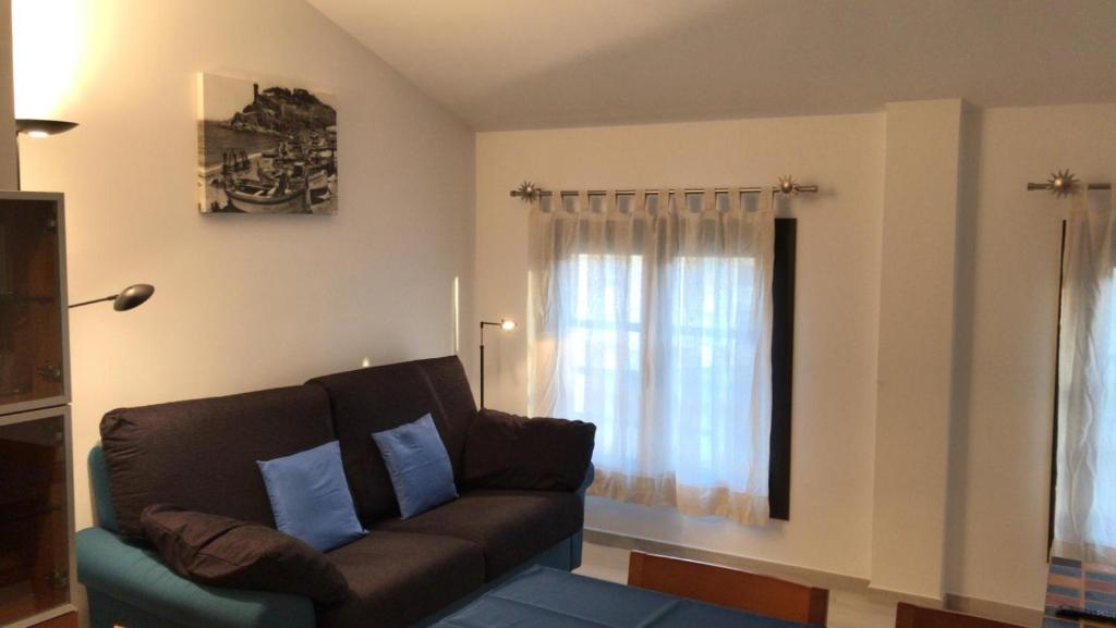 a living room with a couch and a window at Apartament L'Alba 2 in Tossa de Mar