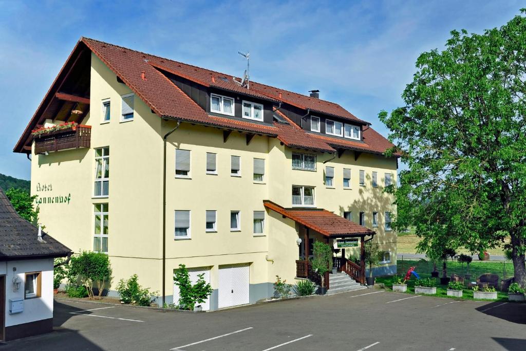 ein großes gelbes Gebäude mit rotem Dach in der Unterkunft Hotel Tannenhof in Steinen