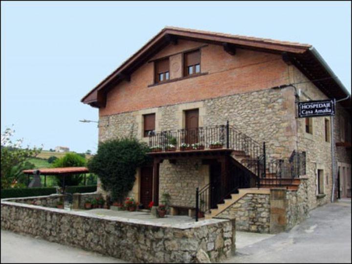 a large brick building with a staircase in front of it at Hospedaje Casa Amalia in Queveda