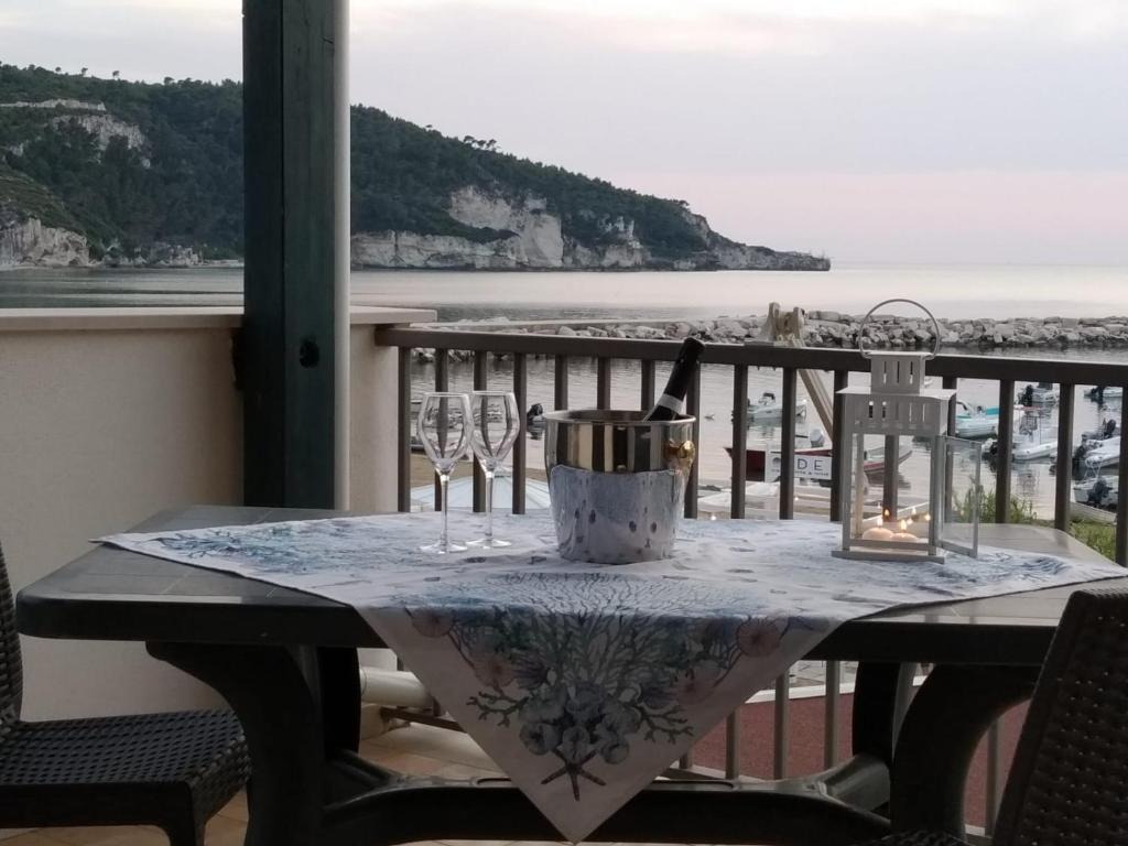 een tafel met wijnglazen en een emmer op een balkon bij Appartamenti Marazzurro in Peschici