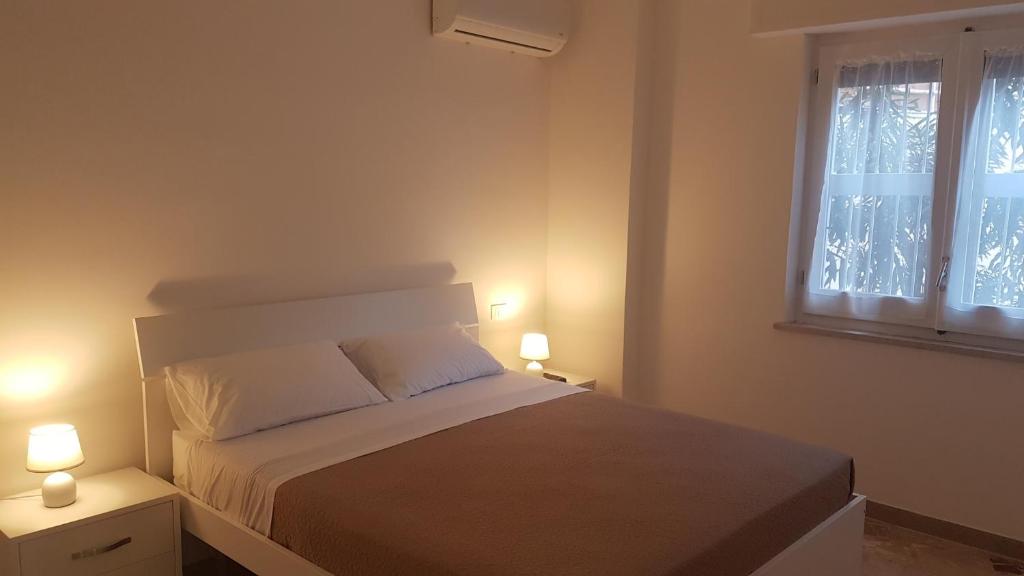 um quarto com uma cama e duas luzes em duas mesas em Clambè em Palermo