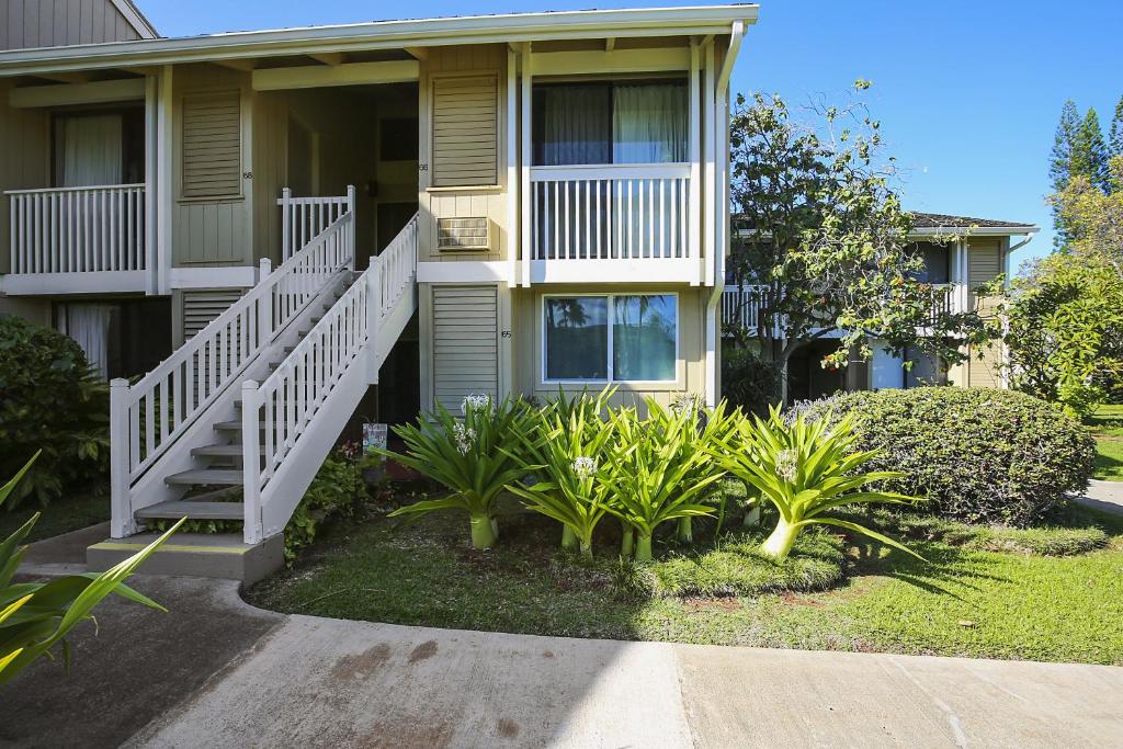 a building with stairs and plants in front of it at Paniolo Condo in Kahuku
