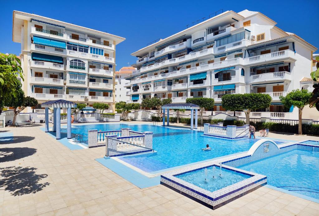 a swimming pool in front of a large apartment building at urb ViñaMar in Torrevieja