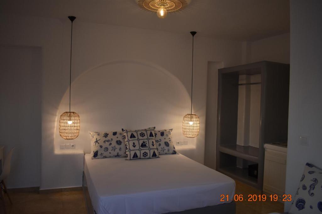 a bedroom with a bed with two lights on it at Infinity Apartments in Naxos Chora