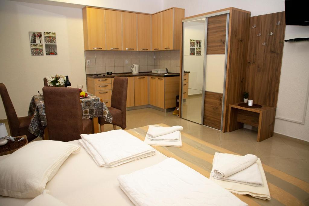 a kitchen with wooden cabinets and white towels on the floor at Villa Andjelina in Budva