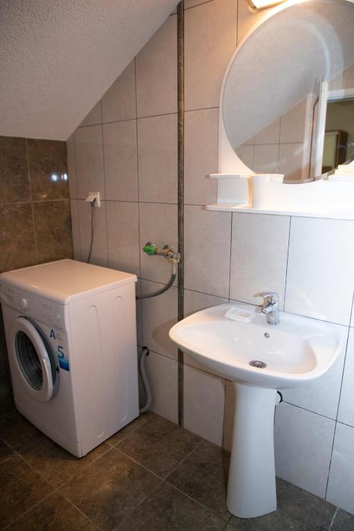 a bathroom with a washing machine and a sink at Villa Andjelina in Budva