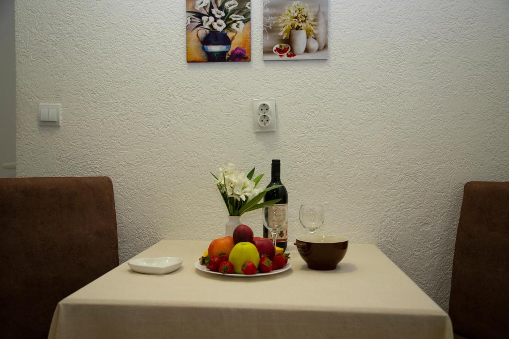 a table with a plate of fruit and a bottle of wine at Villa Andjelina in Budva