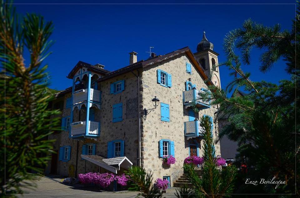 un gran edificio con una torre de reloj encima en La Corte Appartamenti, en Livigno