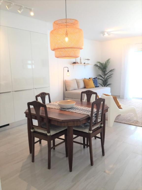 a dining room table and chairs in a living room at Alto Mar Apartment in Peniche
