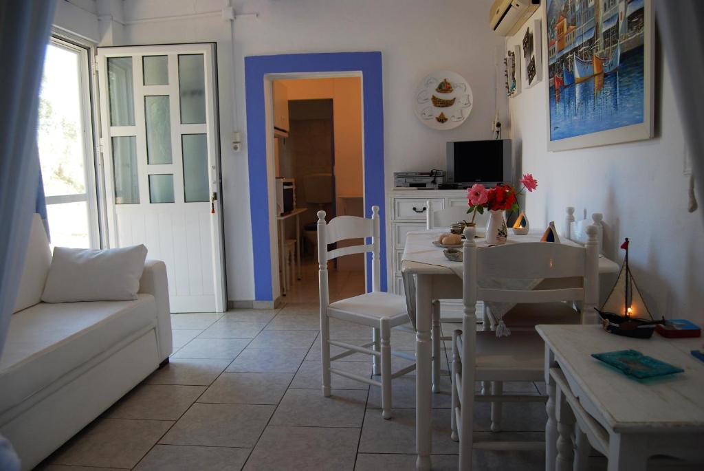 eine Küche und ein Wohnzimmer mit einem Tisch und Stühlen in der Unterkunft KILLINI COTTAGE STUDIO the small cyclades in Kyllini