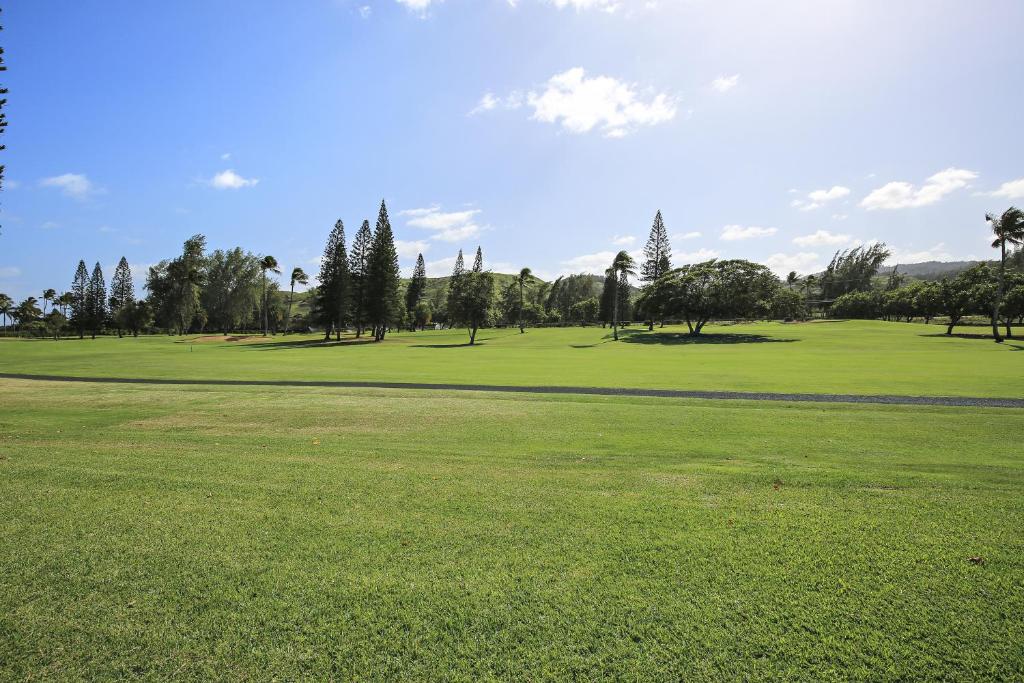 um campo de golfe com árvores e um campo verde em Protea Condo em Kahuku