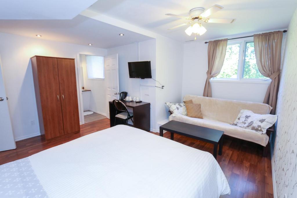 a bedroom with a white bed and a couch at Cedar Drive Inn in Crysler