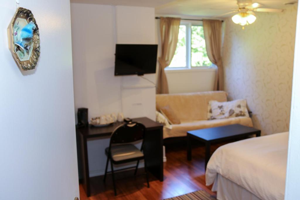 a hotel room with a bed and a couch and a desk at Cedar Drive Inn in Crysler