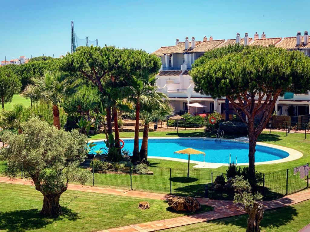 uma imagem de uma piscina num resort em Fantastic 3-Bedroom Holiday Home including Tennis and Pool Near Golf Course em El Portil