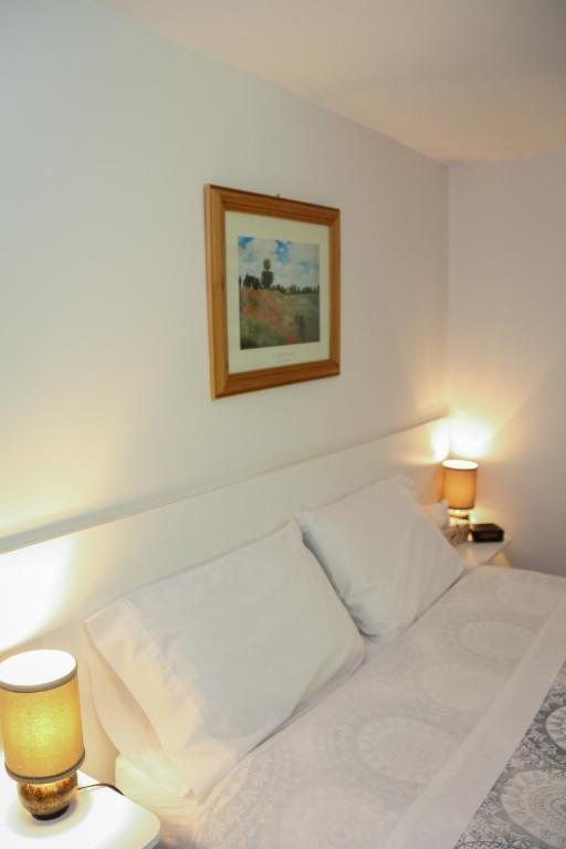 a bedroom with a white bed with a picture on the wall at Cedar Drive Inn in Crysler