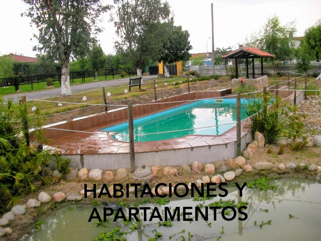 a swimming pool in a park with a playground at La Posada Hípica in Rosalejo