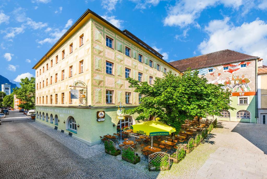 een gebouw met een tafel en stoelen ervoor bij Brauereigasthof/Hotel Bürgerbräu in Bad Reichenhall