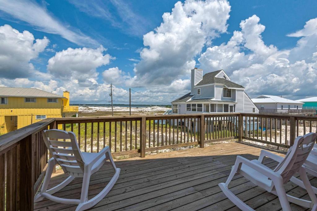 two chairs on a deck with a house and the beach at Sea La Vie Townhouse in Navarre