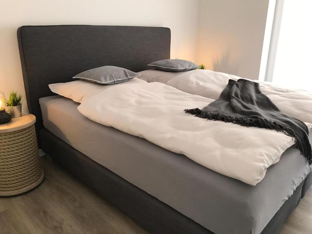 a large bed with white sheets and pillows at Apart Seegras in Büsum